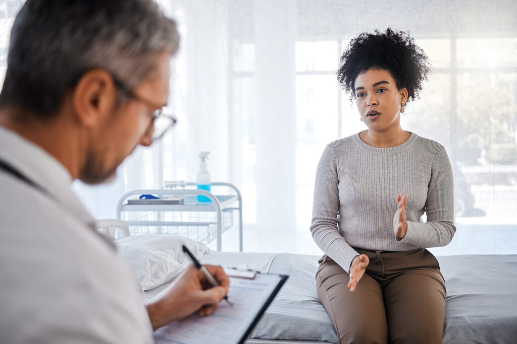 Woman talking to doctor asking for MRI or CT to get answers to pain